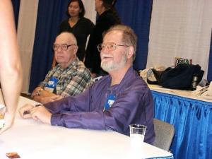 2003: Larry at Torcon 3 (Worldcon 61) on Sunday 31st August, during an autograph session. Hal Clement also pictured in the background. Photo © Keith Stokes used with permission.